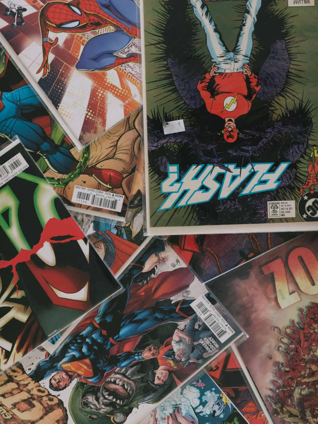 pile of comic books including spider-man, flash, and super-man | taken by joel muniz